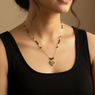 Necklace with a heart pendant worn by a person in a black top against a neutral background